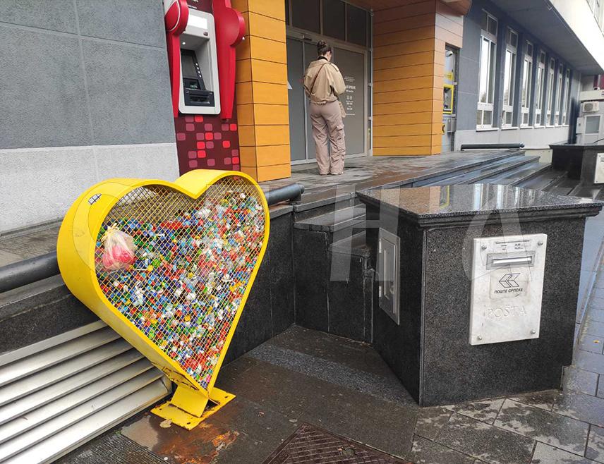 БАЊАЛУКА, 23. ОКТОБРА /СРНА/ - Бројни малишани, уз асистенцију родитеља годинама скупљају пластичне чепове флаша које убацују у жуту металну кутију у облику срца испред зграде "Пошта Српске" у Бањалуци.